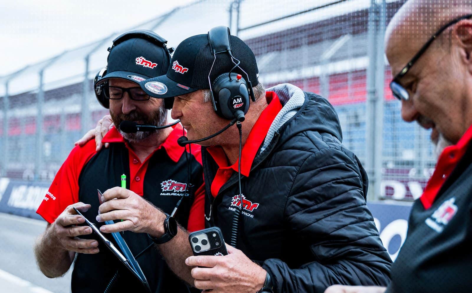 Race engineers reviewing session data trackside on a tablet