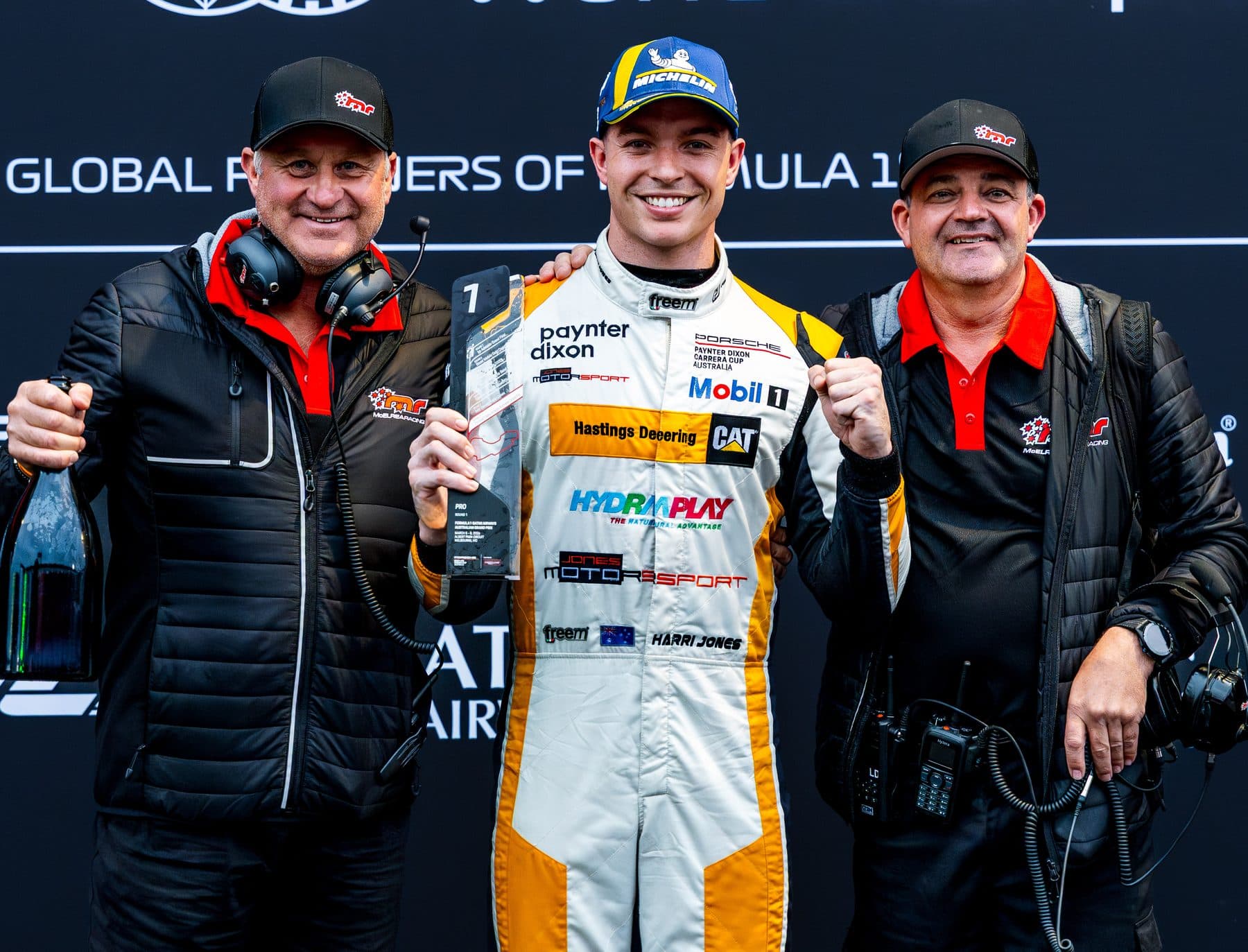 Race team celebrating a podium win with the driver holding the trophy